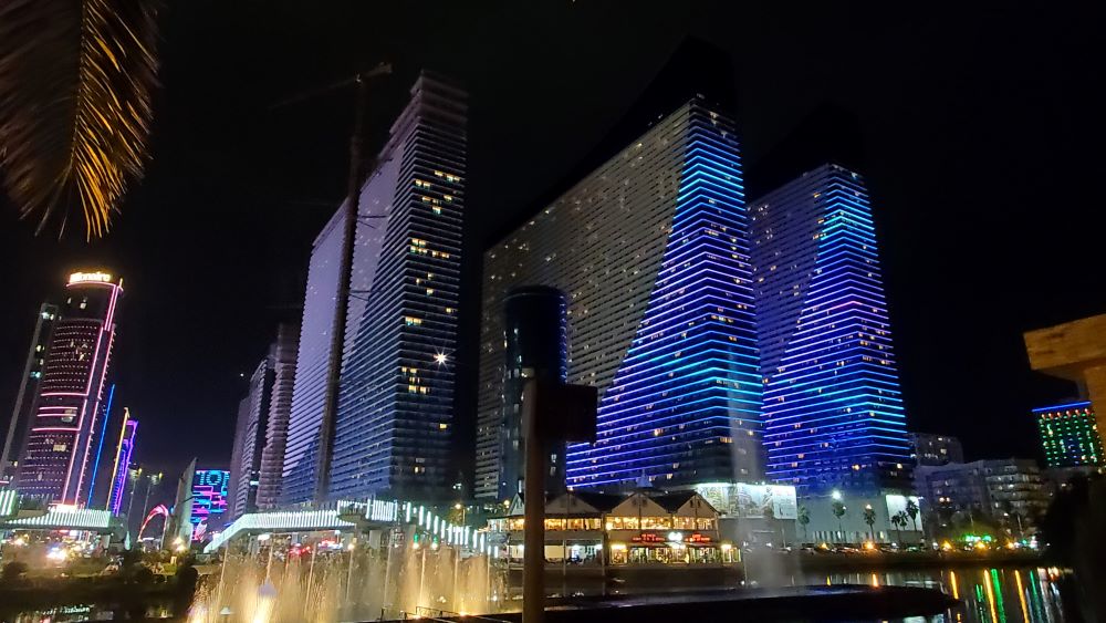 trois grands resorts immobiliers illuminés de violet à la nuit tombée (Orbi city)