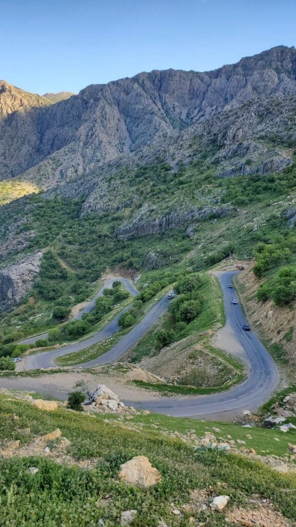 route de montagne qui serpente dans une vallée verdoyante en Iran