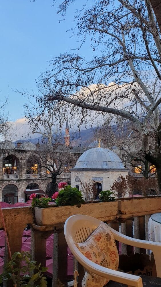 vue du Khan ottoman de Bursa en hiver à la lumière du soir, arbre sans feuille et dôme ottoman et minaret