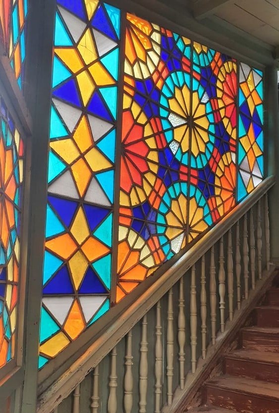 la cage d'escalier de la kaleidoscope House à Tbilissi avec ses vitraux géométriques colorés